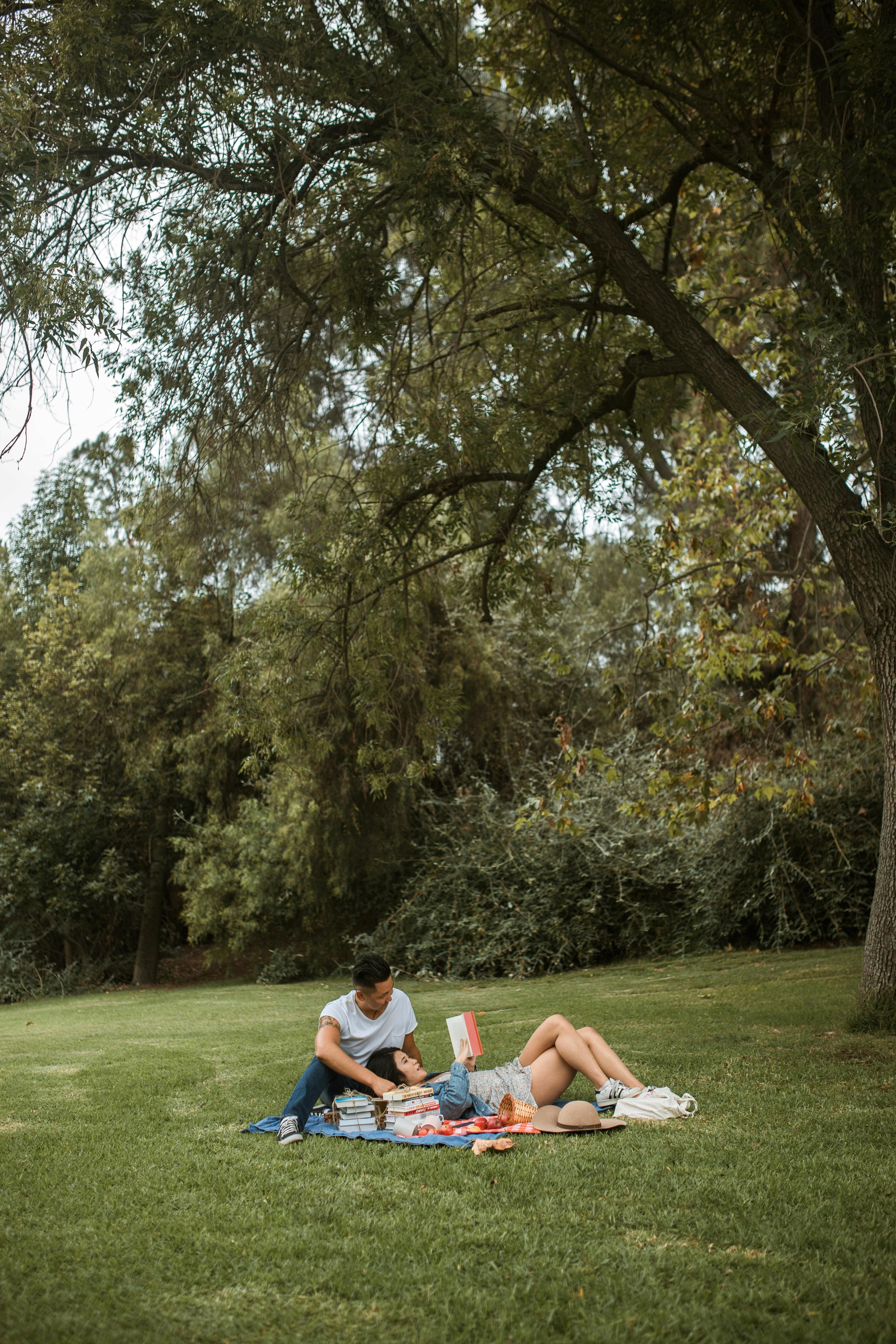 Two people sitting on the grass using a laptop.